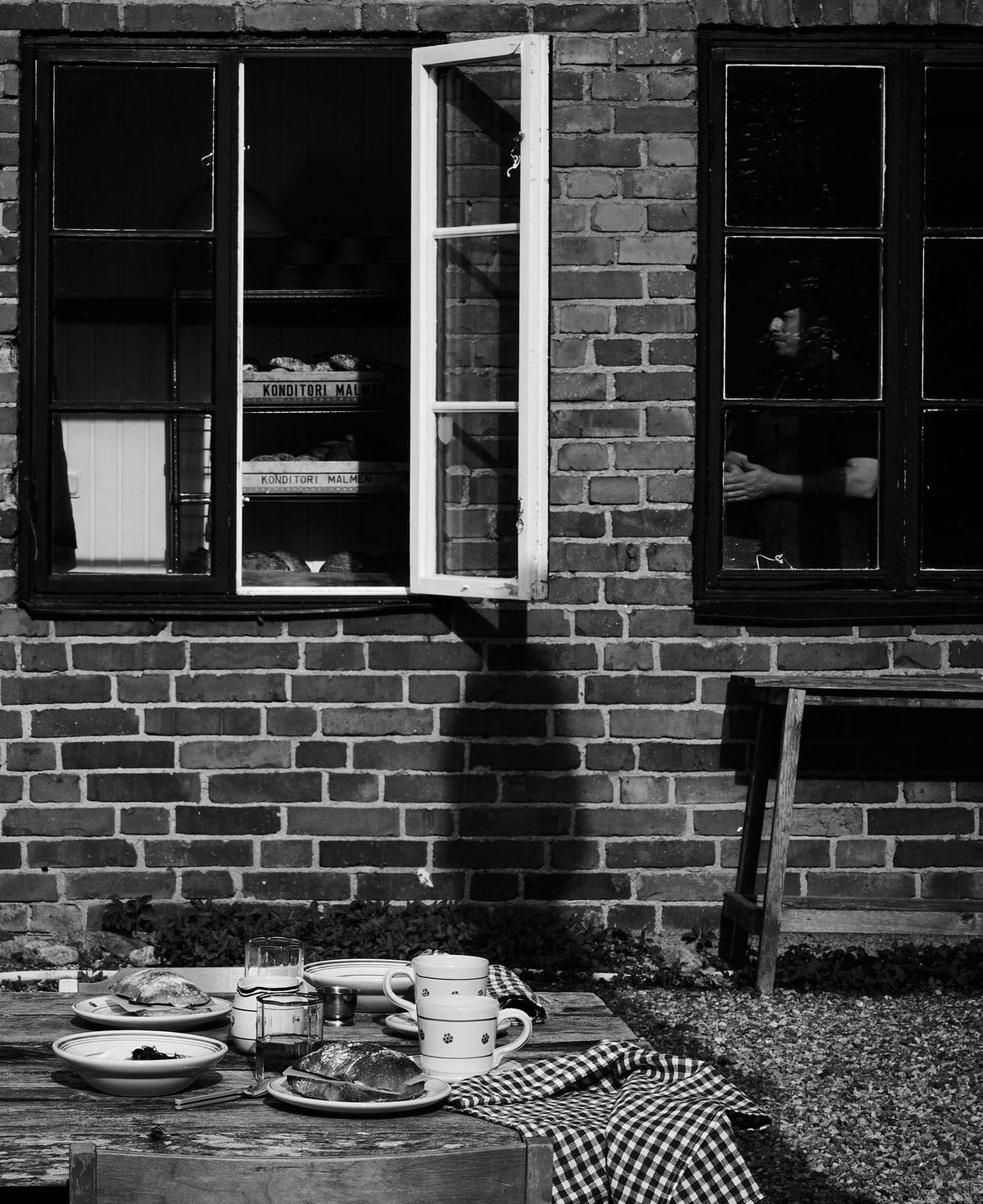 Open window in the brick façade with pastries on a tray inside