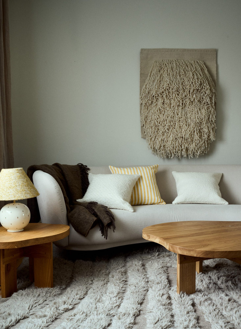 Soffa med prydnadskuddar och pläd